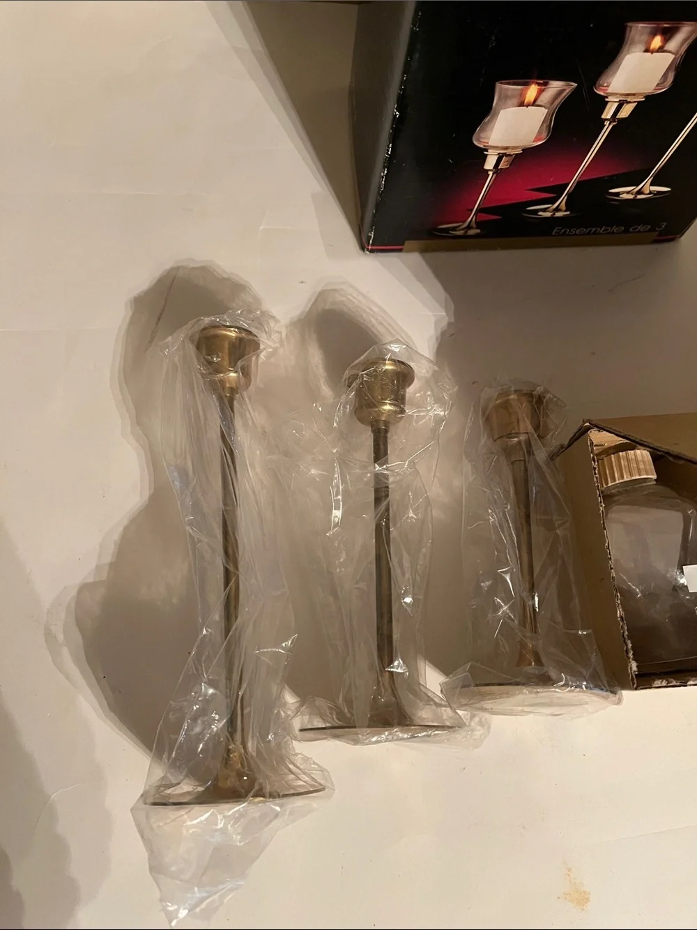 Vintage graduated brass candlestick holders with hurricane glass shades – three